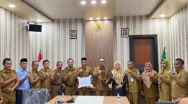 Kepala DP3A Malut saat menyerahkan piagam penghargaan KLA kepada Bupati Halmahera Barat. 