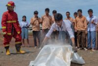 Siswa SMA Tunas Muda Kawasi diberikan kesempatan langsung untuk memadamkan api di lapangan.