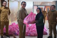 Sekretaris DPRD Malut, Abubakar Abdullah saat menyerahkan bantuan sembako ke cleaning servis. (Foto: Gocan Setwan). 