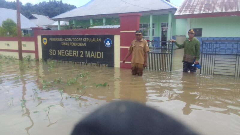 Camat Oba Selatan, Udin Hasan di depan SD Negeri 2 Maidi tergenang air. 