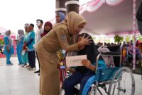 Staf ahli, Hairiah saat merangkul penuh kasih salah satu siswi SLB. 

Staf ahli, Hairiah saat merangkul penuh kasih salah satu siswi SLB. 