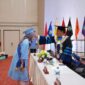 Toga biru muda ala wisudawan Unibrah, terlihat Rektor Sarbaini A Karim memindahkan tali toga. 