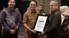 Pj Sekprov Malut menyerahkan piagam penghargaan.