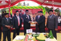 Pj Gubernur menyerahkan potongan tumpeng pada Kakanwil Kemenag Malut. 