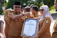 Pj Gubernur Malut menyerahkan piagam penghargaan OPD inovatif kepada Kadis DP3A. 