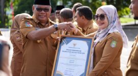 Pj Gubernur Malut menyerahkan piagam penghargaan OPD inovatif kepada Kadis DP3A. 