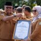 Pj Gubernur Malut menyerahkan piagam penghargaan OPD inovatif kepada Kadis DP3A. 