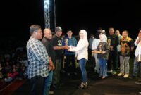 Bupati Kepulauan Sula, Fifian Adeningsi Mus didampingi Ketua Panitia HUT Kabupaten ke-22, Kamarudin Mahdi, menyerahkan piagam penghargaan kepada Kepala Desa yang meraih juara lomba kategori Desa bersih. (Dokumentasi: Diskomdigi)