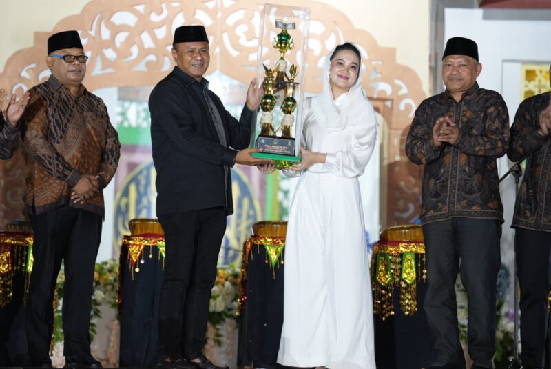 Gubernur Maluku Utara, Sherly Laos menyerahkan piala juara umum kepada Wali Kota Tidore Kepulauan, Muhammad Senen. 