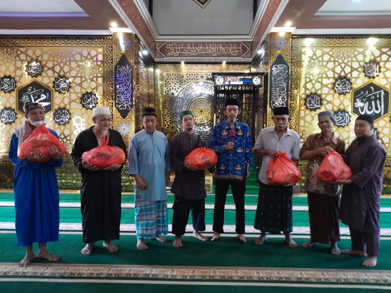 Ketua BKM Al-muhajirin foto bersama dengan penerima bantuan sembako. 