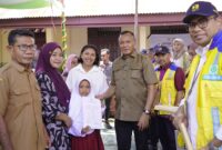 Wali Kota Tidore, Muhammad Sinen dan anggota DPR RI, Irine Y. Roba menyerahkan bantuan beasiswa kepada siswa. 