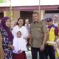 Wali Kota Tidore, Muhammad Sinen dan anggota DPR RI, Irine Y. Roba menyerahkan bantuan beasiswa kepada siswa. 