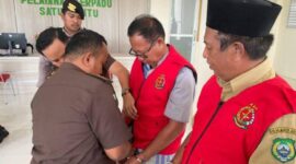 Dua tersangka Sahril Abdul Rajak dan S.S mengenakan rompi merah khas kejaksaan. 