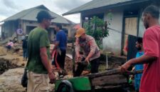 Anggota Polres Sula mambantu masyarakat Desa Waisakai yang terdampak banjir.