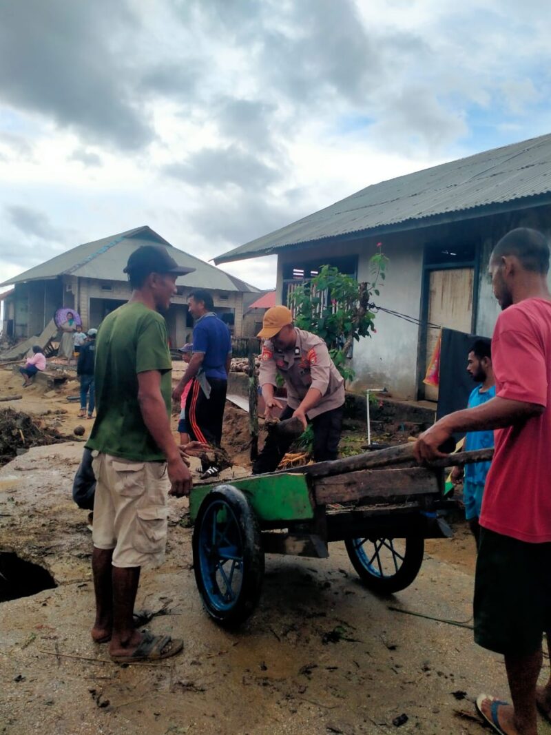 Anggota Polres Sula mambantu masyarakat Desa Waisakai yang terdampak banjir. 