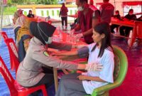 Anggota Bidokes Polres Halteng memberikan pelayanan kesehatan gratis kepada warga Sibenpopo di pengungsian. 