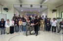 Foto bersama peserta dan Kepala Bidang Pengawasan K3, Nirwan M. Turuy menyerahkan atribut pelatihan kepada salah satu peserta. 