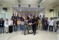 Foto bersama peserta dan Kepala Bidang Pengawasan K3, Nirwan M. Turuy menyerahkan atribut pelatihan kepada salah satu peserta. 