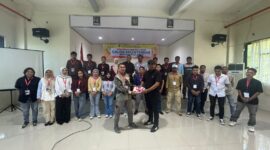 Foto bersama peserta dan Kepala Bidang Pengawasan K3, Nirwan M. Turuy menyerahkan atribut pelatihan kepada salah satu peserta. 
