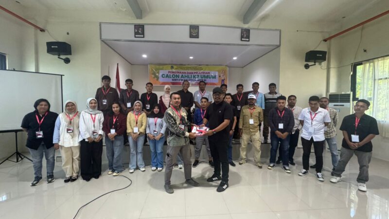 Foto bersama peserta dan Kepala Bidang Pengawasan K3, Nirwan M. Turuy menyerahkan atribut pelatihan kepada salah satu peserta. 